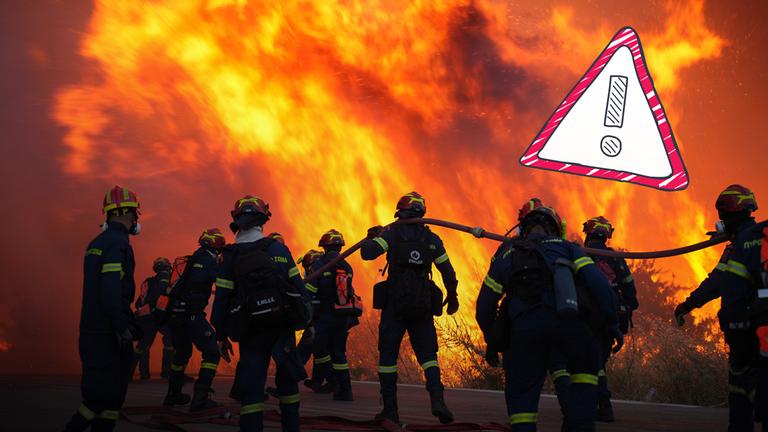 Feuerwehrmänner mit Schlauch vor Brand