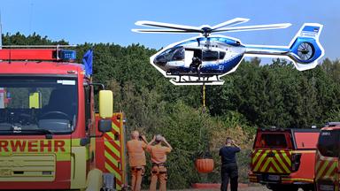 Feuerwehrfahrzeuge und ein Polizeihubschrauber