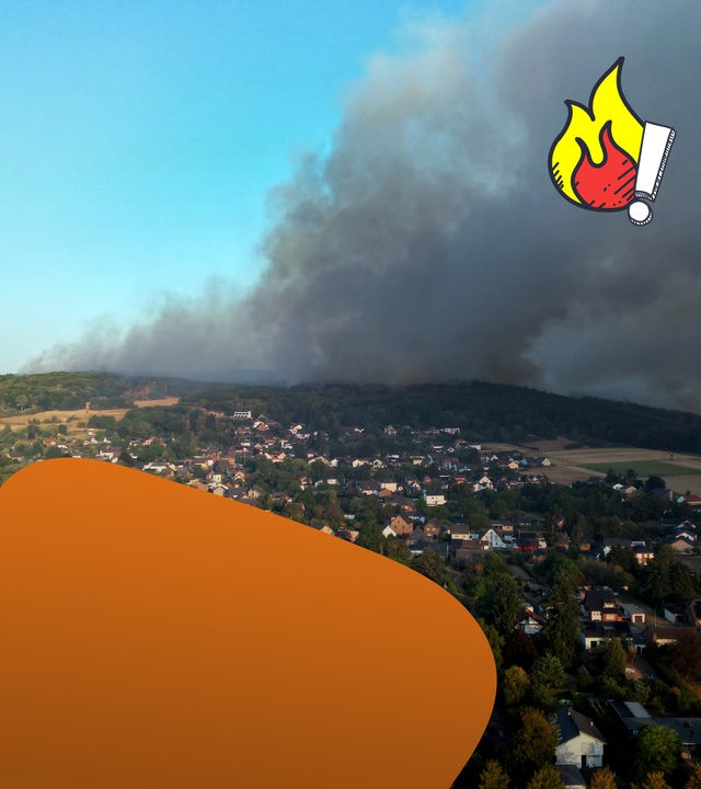 Kleiner Ort, im Hintergrund große Rauchwolke