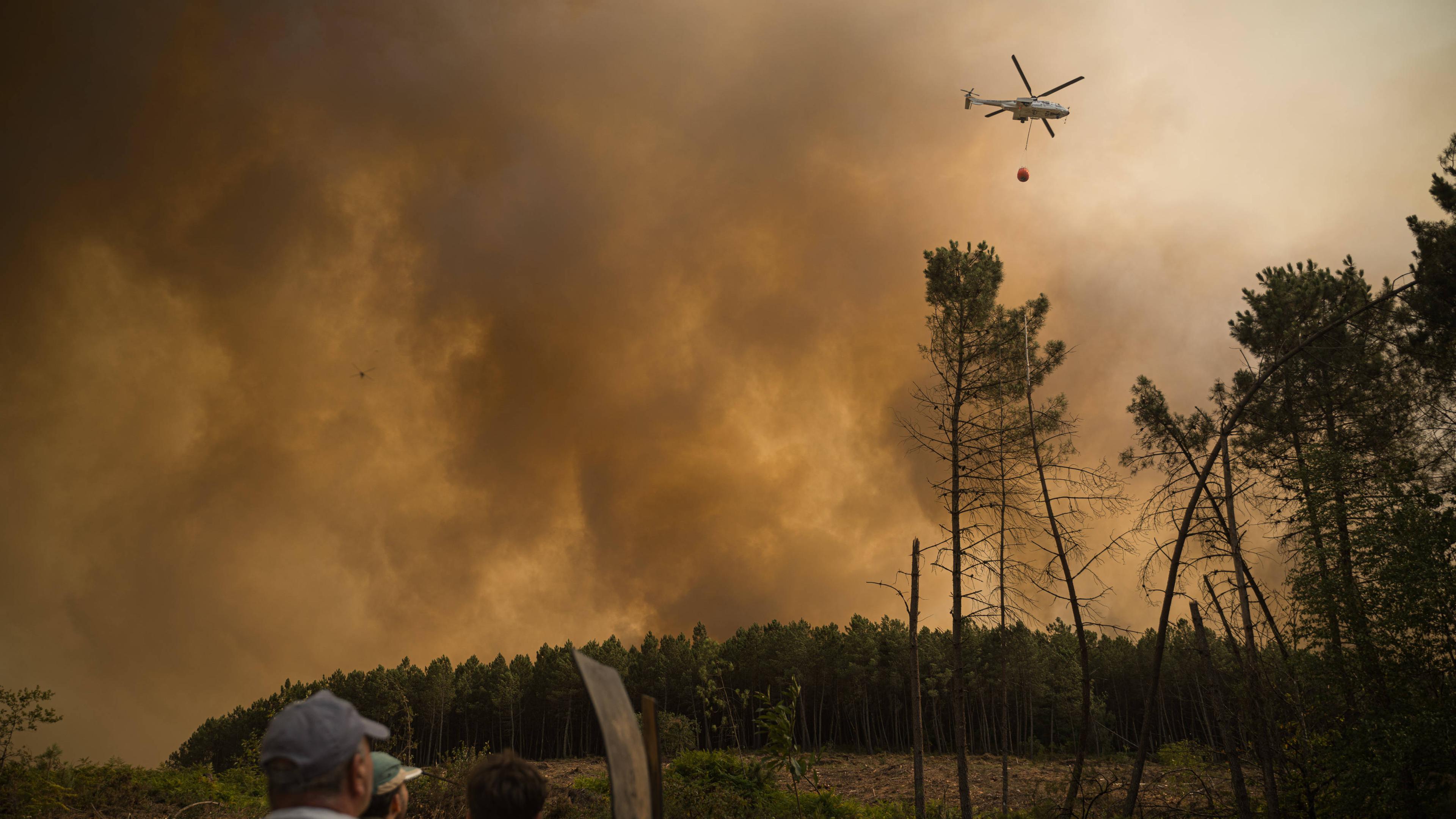 Ein Hubschrauber löscht einen Waldbrand aus der Luft.