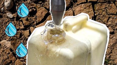 Wasserkanister mit Wassertropfen und im Hintergrund ausgedörrter Boden