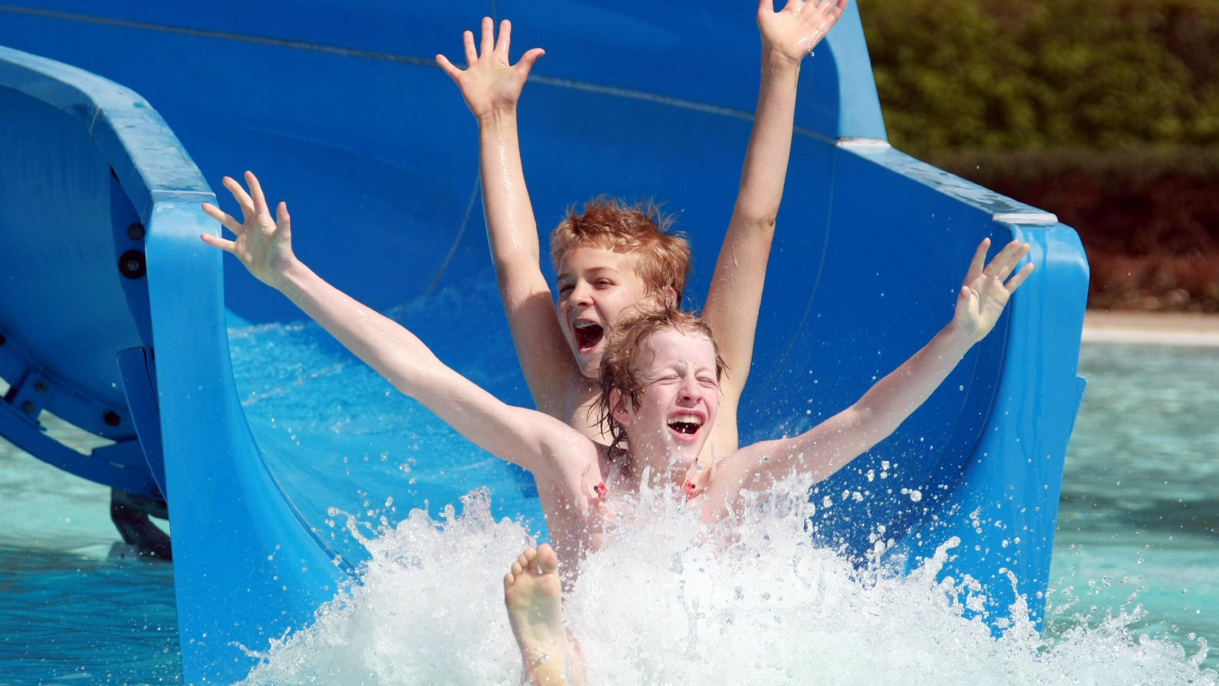 Kinder rutschen Wasserrutsche hinunter 
