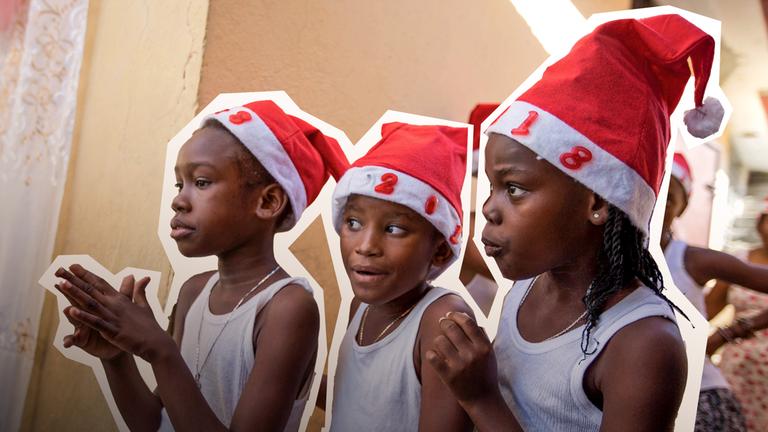 Drei Mädchen stehen am 22.12.2017 in Port-au-Prince (Haiti) während einer Weihnachtsveranstaltung hinter einer Bühne