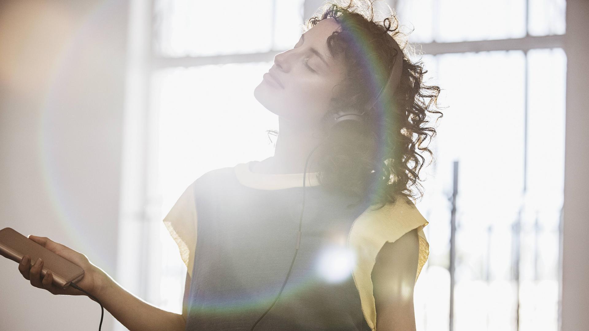 Eine junge Frau hört Musik und tanzt 