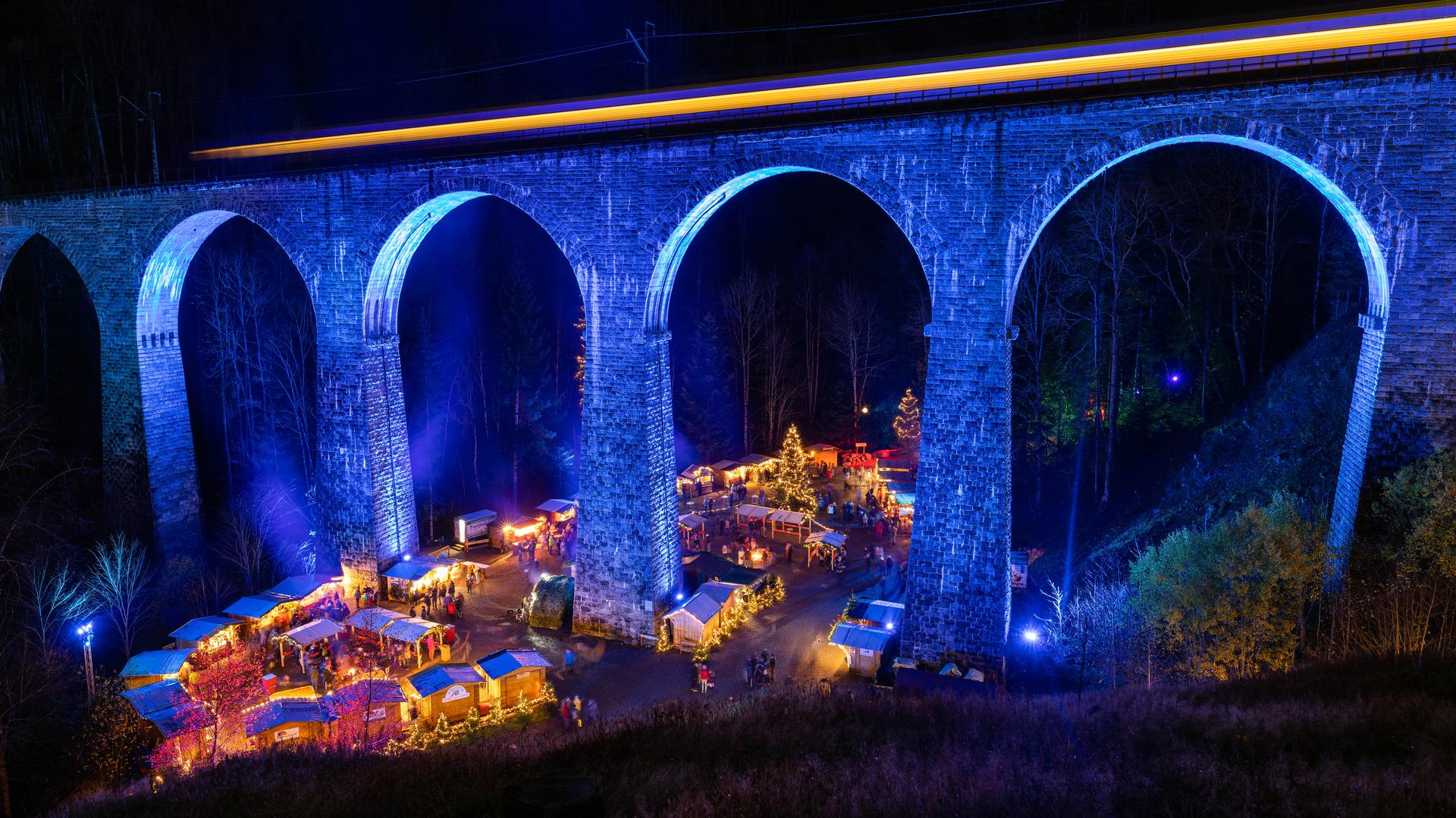 Das beleuchtete Viadukt der Ravennaschlucht,  darunter findet ein Weihnachtsmarkt statt.