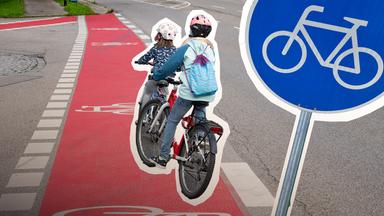 Zwei Mädchen fahren auf einem Radweg