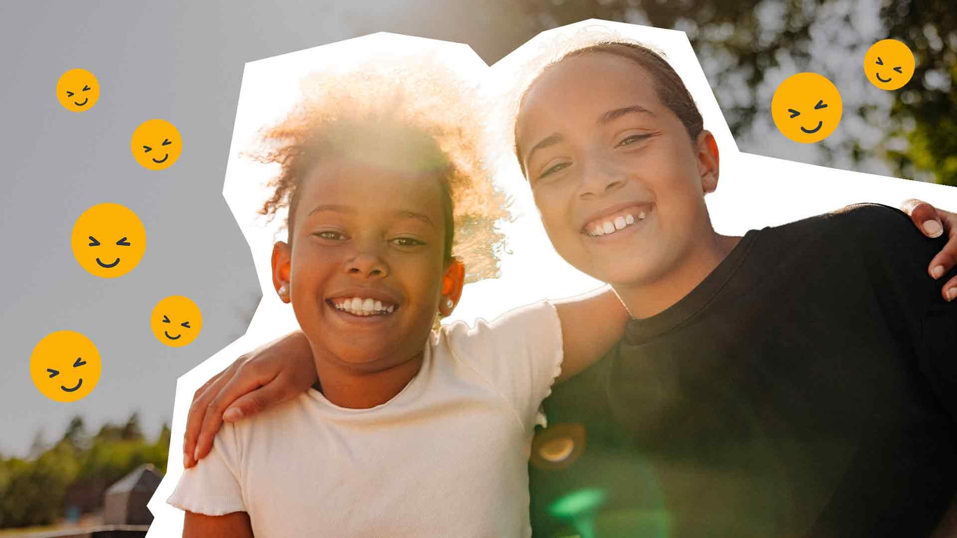 Zwei Mädchen schauen in die Kamera, haben die Arme über die Schultern gelegt und lachen. Daneben sind lachende Smileys zu sehen.