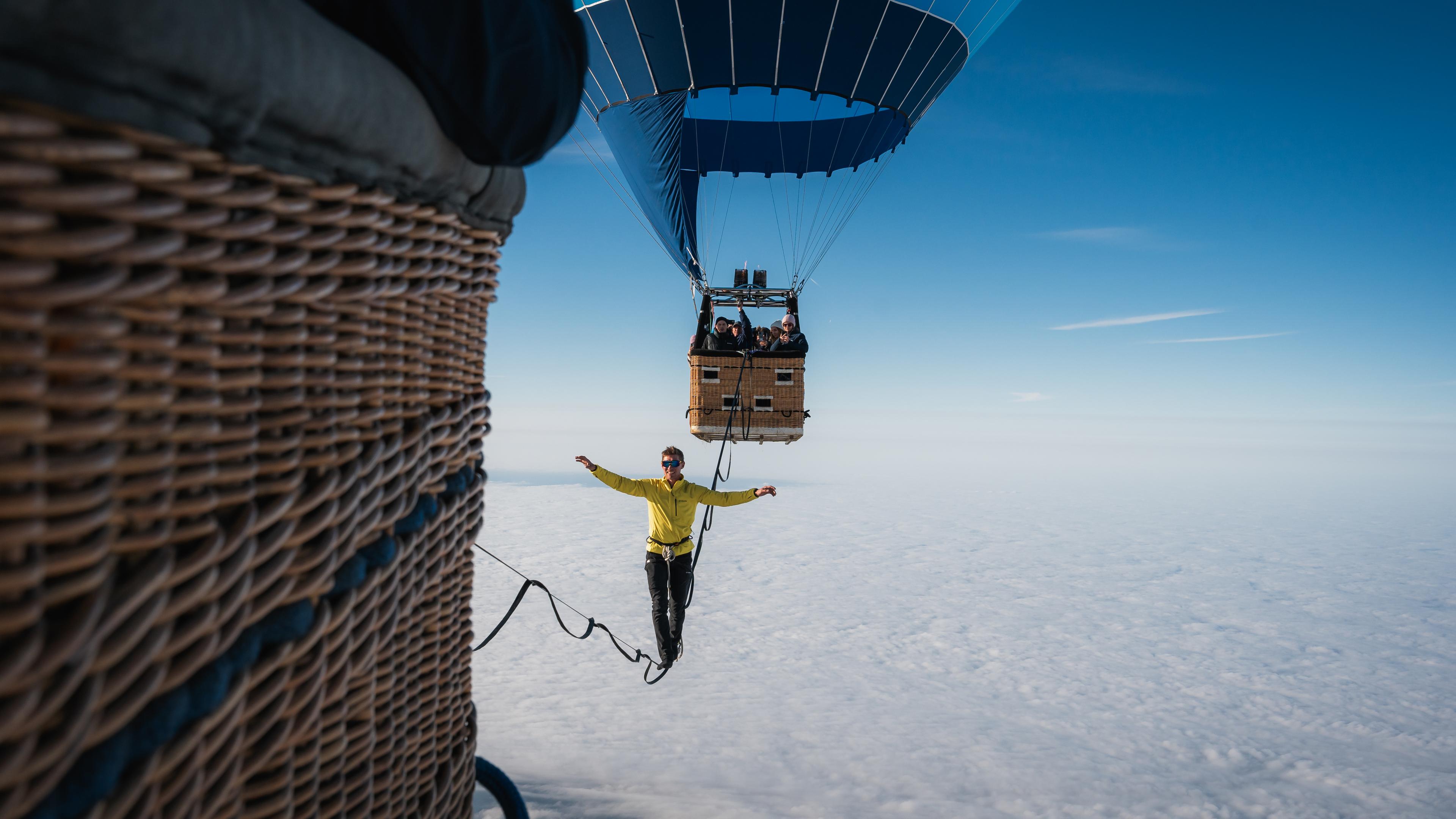 Extremsportler Lukas Irmler überquert in 2.500 Metern Höhe eine Slackine, die zwischen zwei Heißuftballons gespannt ist.