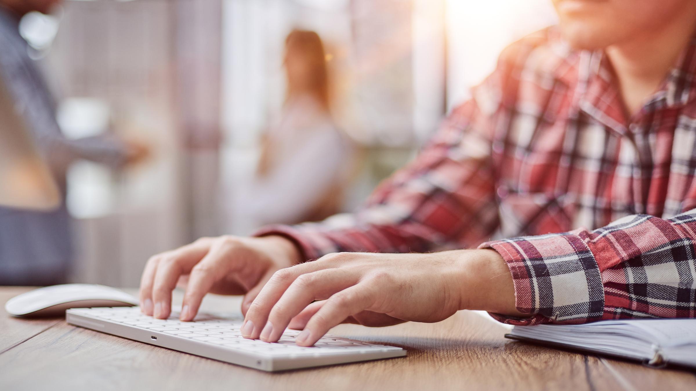 Mann tippt auf Tastatur