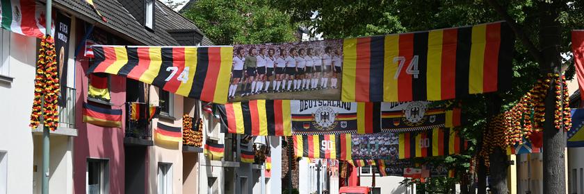 Eine Straße in Essen Altendorf ist mit Fahnen und Girlanden in Deutschlandfarben geschmückt.