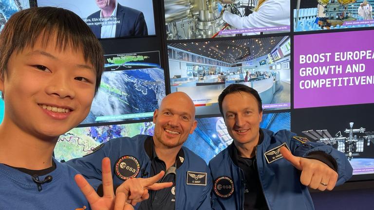 Alexander Gerst und Matthias Maurer machen mit Kinderreporter Yan ein Selfie.