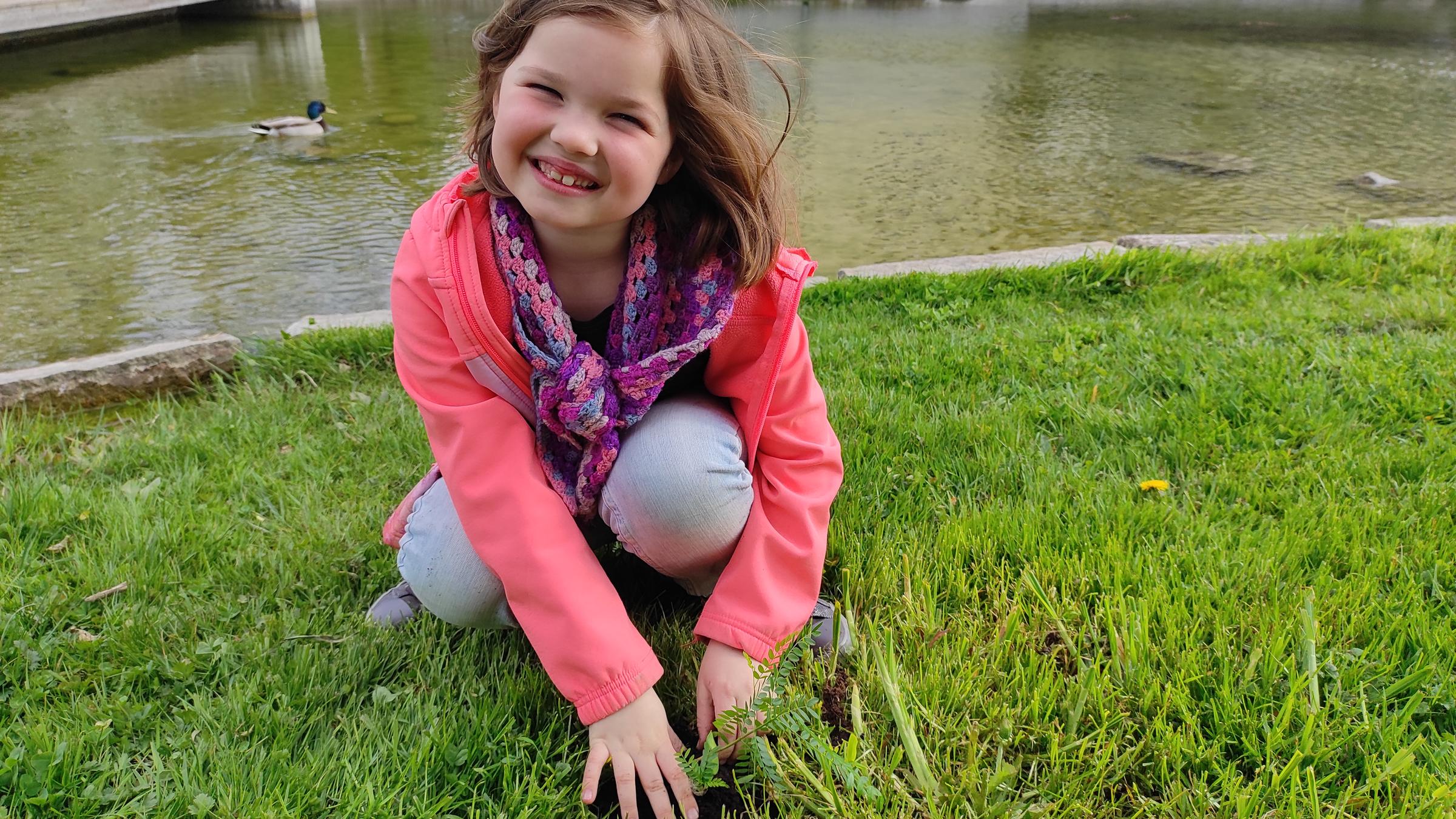 Ylvi kniet stolz vor ihrem Lederhülsenbaum