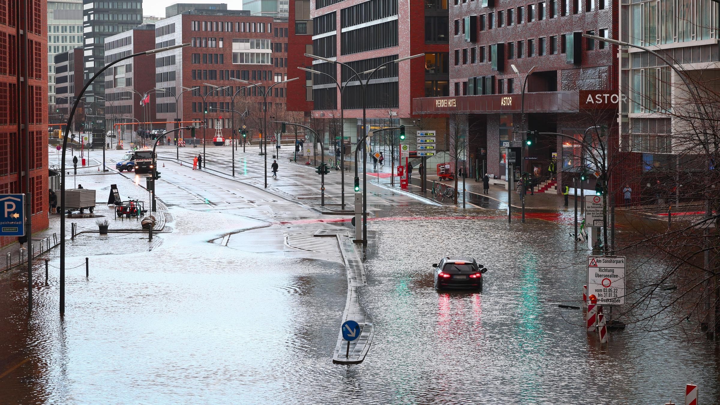 Ein Fahrzeug steckt auf der überschwemmten Straße